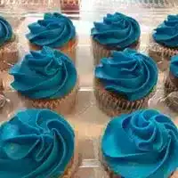 Assorted mini classic cupcakes with vibrant blue frosting, perfect for celebrations. Freshly baked with smooth, swirled icing, ideal for special occasions and dessert tables.