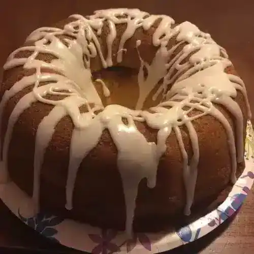Delicious banana pudding cake topped with creamy white icing drizzle, perfect for special occasions and dessert lovers.