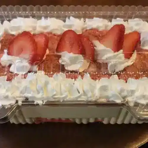 Delicious Lemon Delight cake with fresh strawberries and whipped cream, perfect for celebrations.