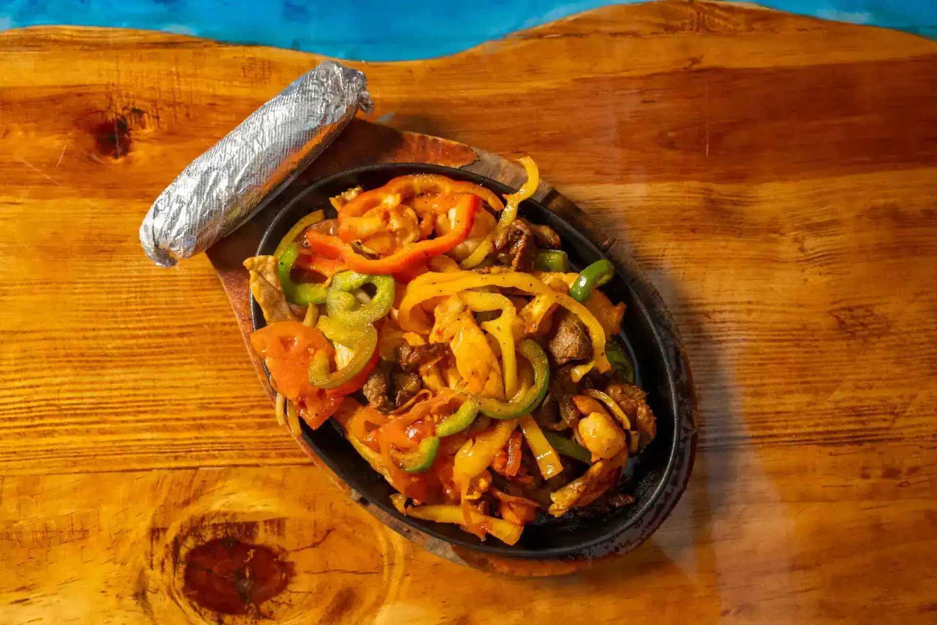 Colorful fajitas with peppers and onions served on a sizzling skillet.