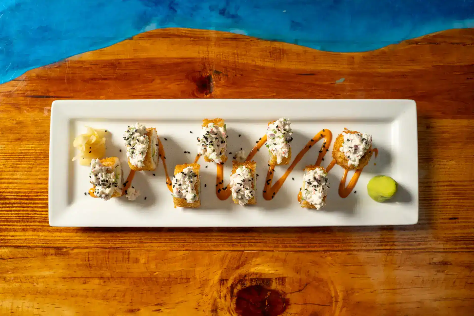 Delicious sushi roll with sauce and wasabi on white plate.