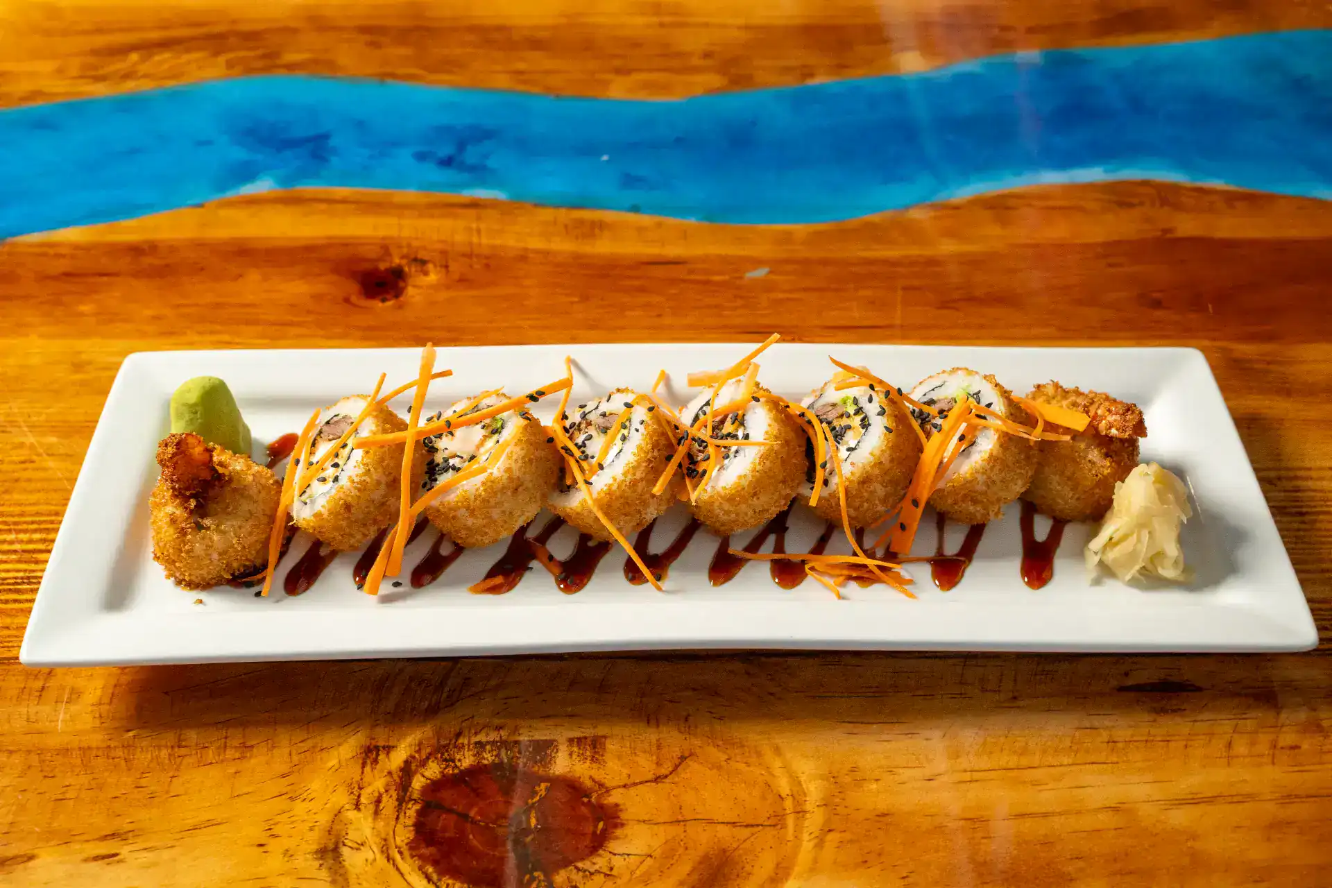 Delicious sushi roll with seafood and beef on a white plate.