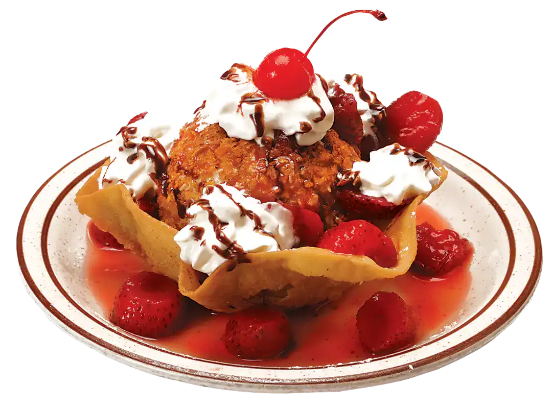 Nieve Frita dessert topped with whipped cream, cherries, and chocolate drizzle.