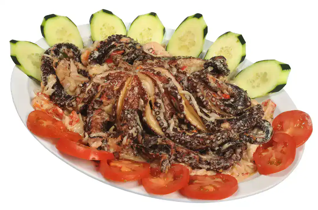 Fresh octopus dish with cucumber and tomato garnishes.