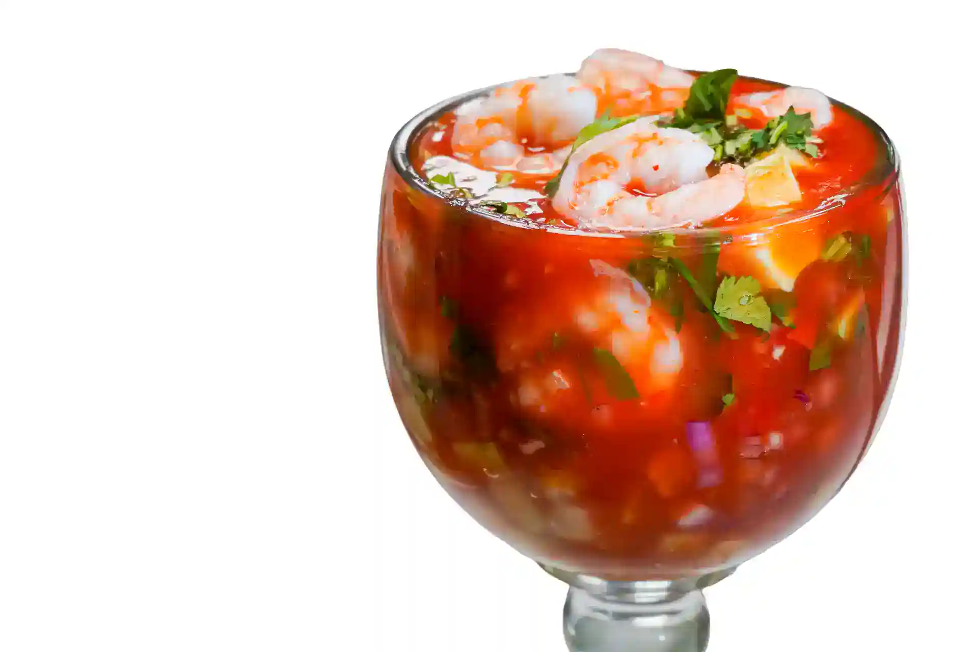 Seafood cocktail with shrimp, tomatoes, and herbs in a glass.