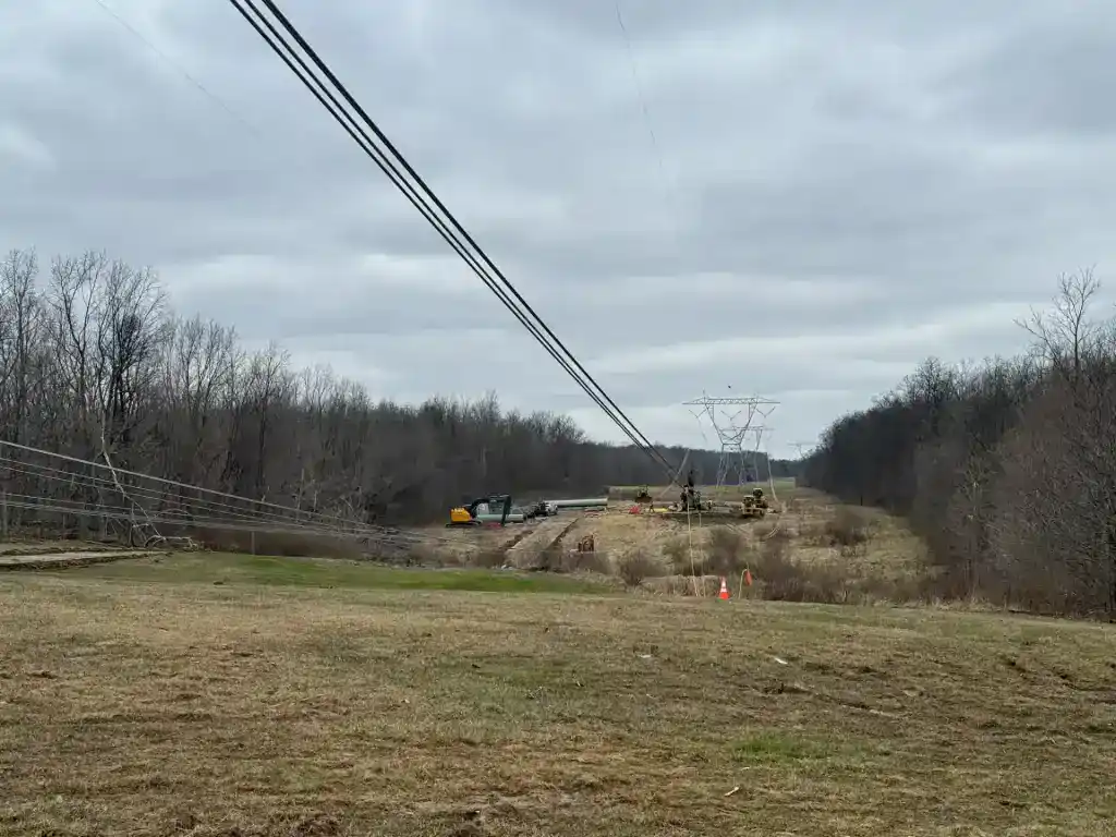 Repair crew working on fallen 765kV power line after storm damage.
