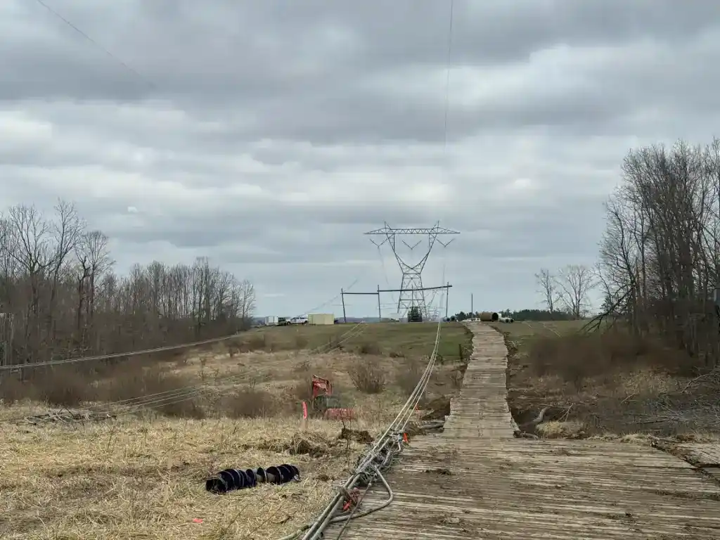 Power line repair site with damaged towers and fallen lines.