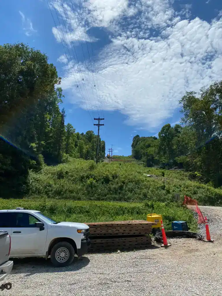 High-voltage transmission towers in Southeast Ohio under a partly cloudy sky.