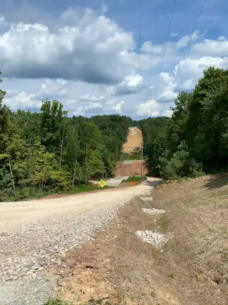 Construction site of Southeast Ohio transmission line with dirt road and power lines.