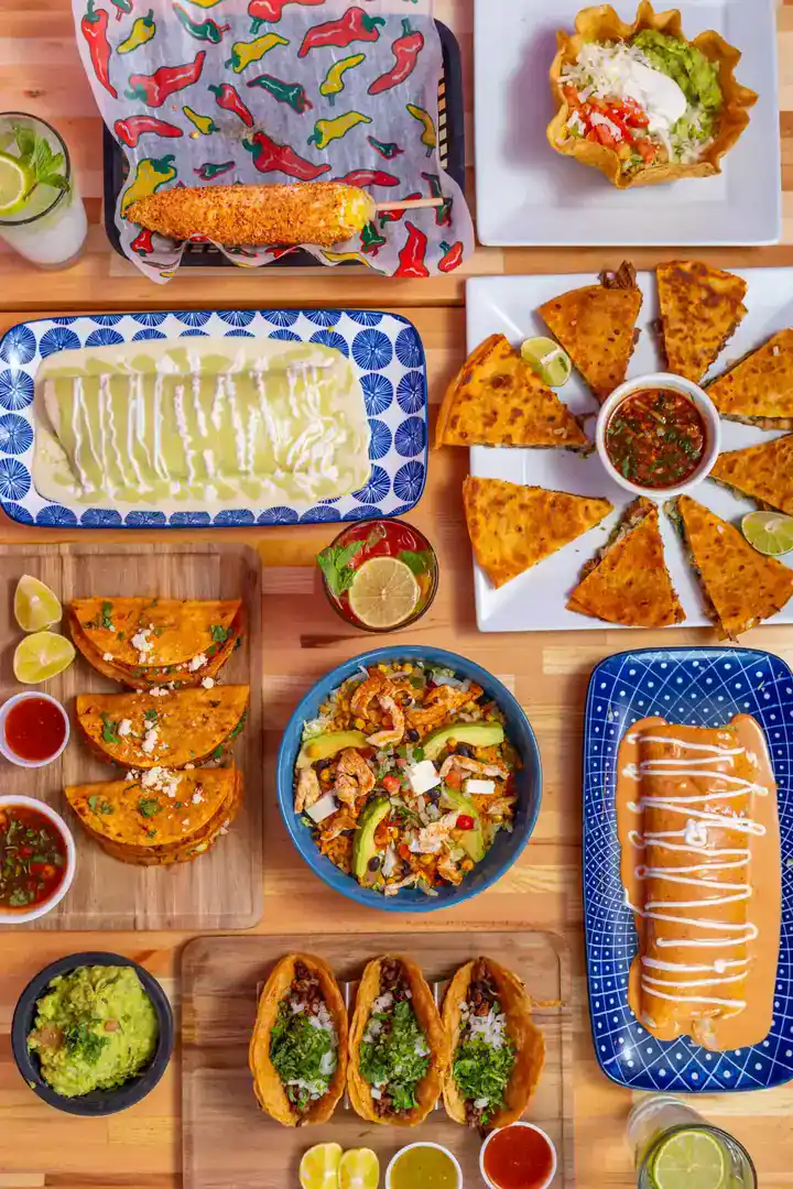 Assorted Mexican dishes including tacos, nachos, and fried fish at El Mesquite Mexican Bar & Grill.