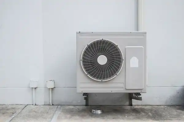 A professionally installed outdoor heat pump sits securely on a concrete pad beside a white wall, providing reliable comfort for this Las Vegas home. At Fetch‑A‑Tech, our friendly, family-owned team is dedicated to creating comfortable spaces with honest, helpful service you can trust.