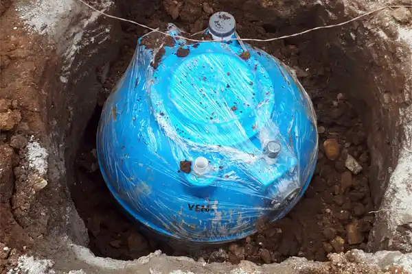 A blue underground water tank, carefully wrapped for protection, is being installed in a freshly prepared pit in the Las Vegas soil. At Fetch‑A‑Tech, our family-owned team ensures every installation is done with care to provide long-lasting comfort and reliable service for your home.