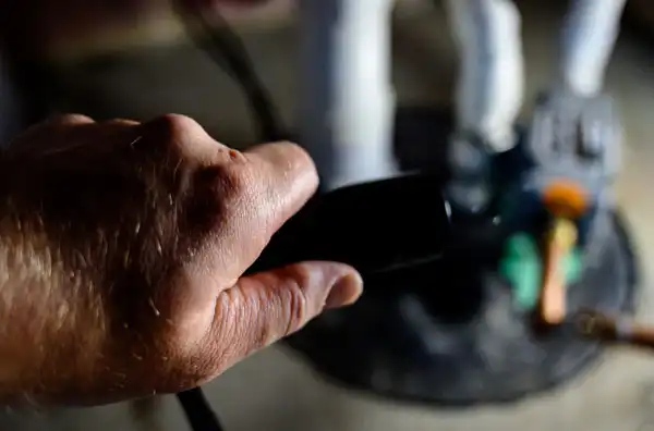 A close-up of a friendly technician’s hand holding a black tool, ready to help with your comfort needs. Blurred equipment in the background highlights our family-owned Fetch‑A‑Tech team’s commitment to honest, reliable service for Las Vegas homes and businesses.