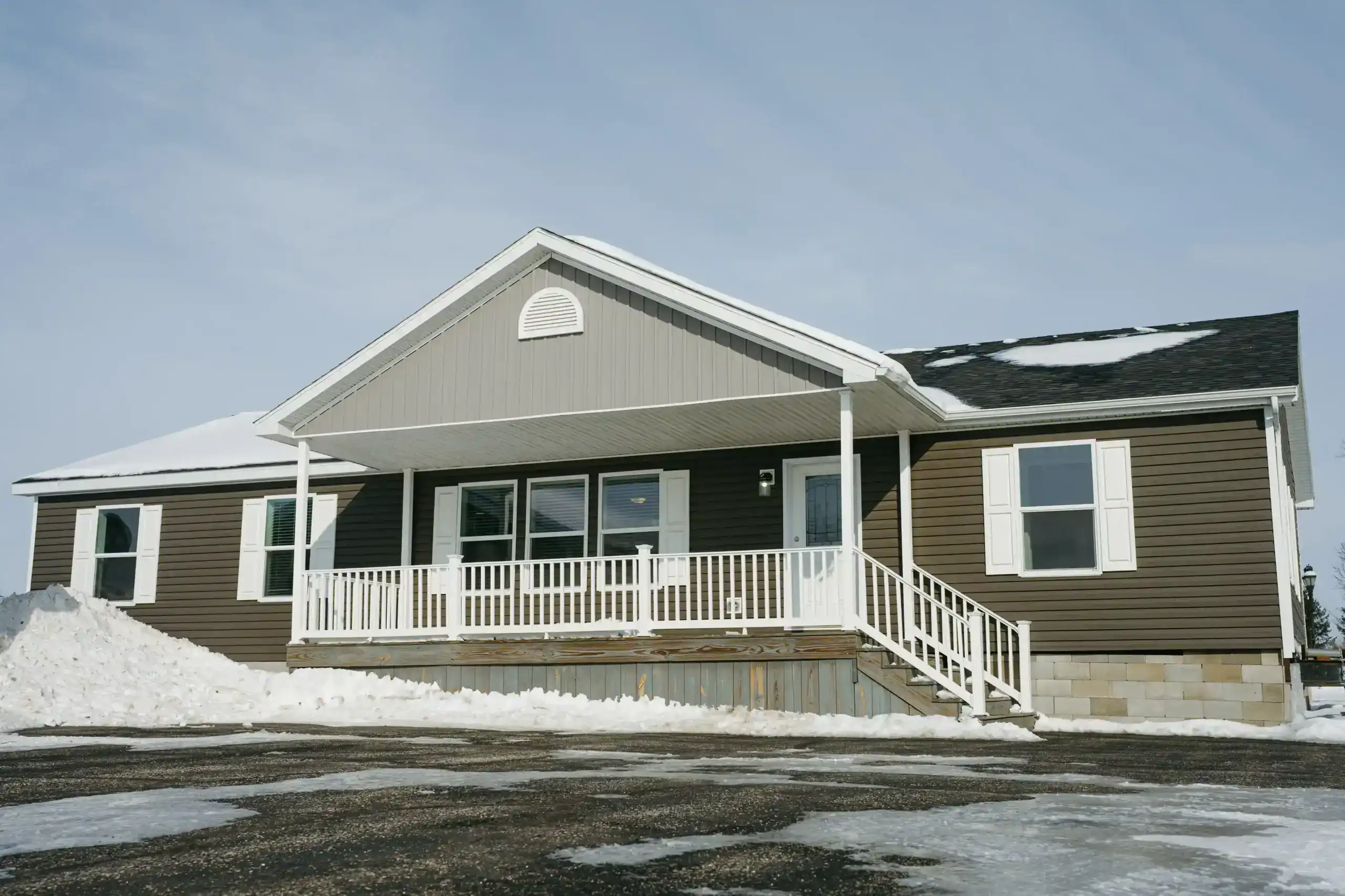 Modular home with a covered front porch in winter.