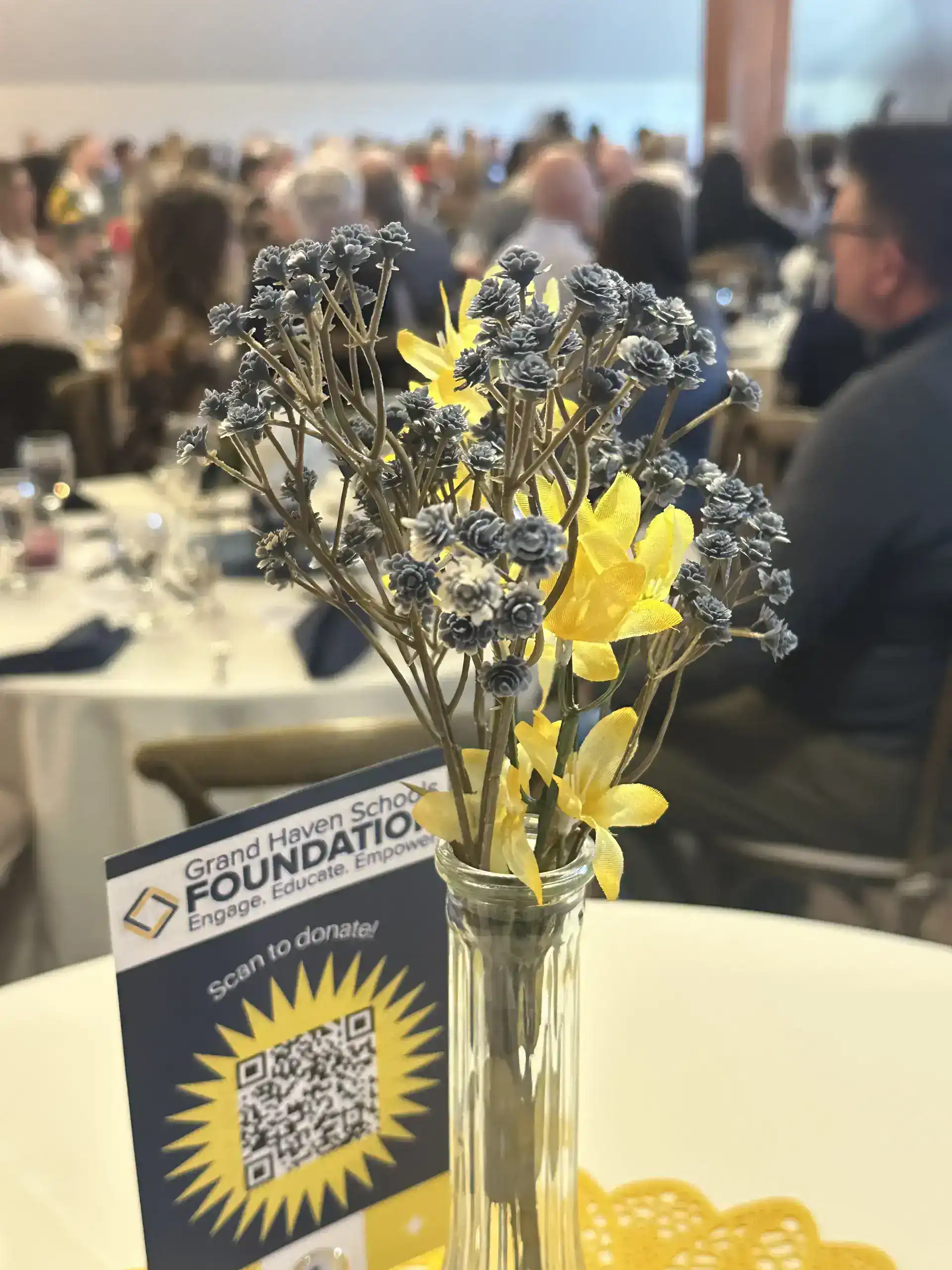 Flower arrangement with yellow and gray flowers at GHSF event.