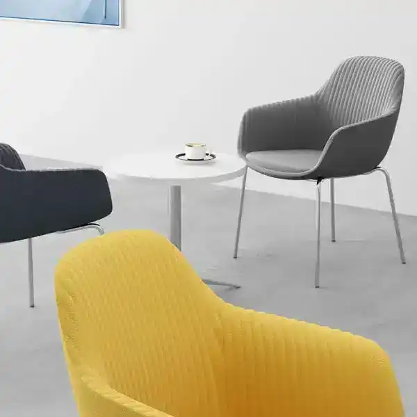 Contemporary office lounge with colorful chairs and small table.