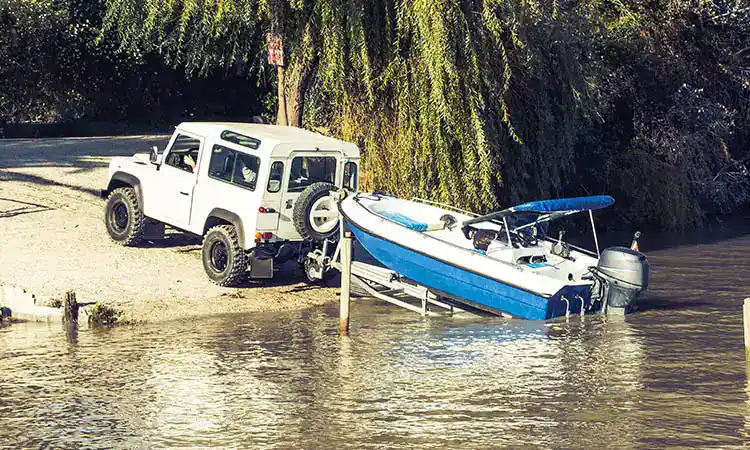 Off-road vehicle and boat parked by the water at Hall's Sport Center.