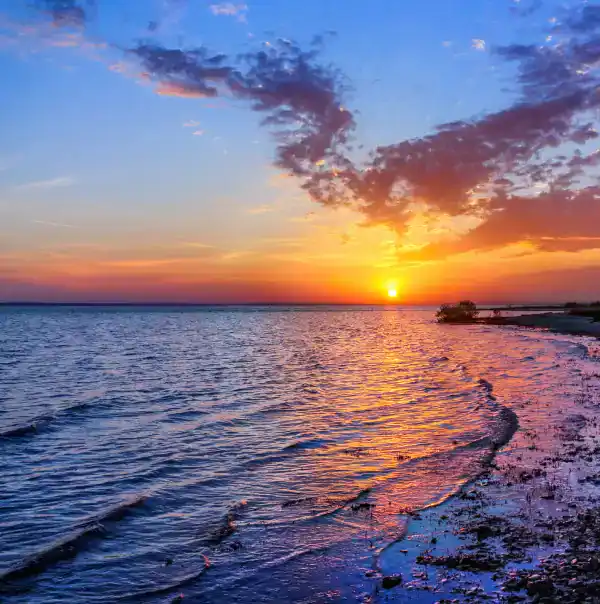 Beautiful sunset scene at Hall's Sport Center with ocean and vibrant sky.