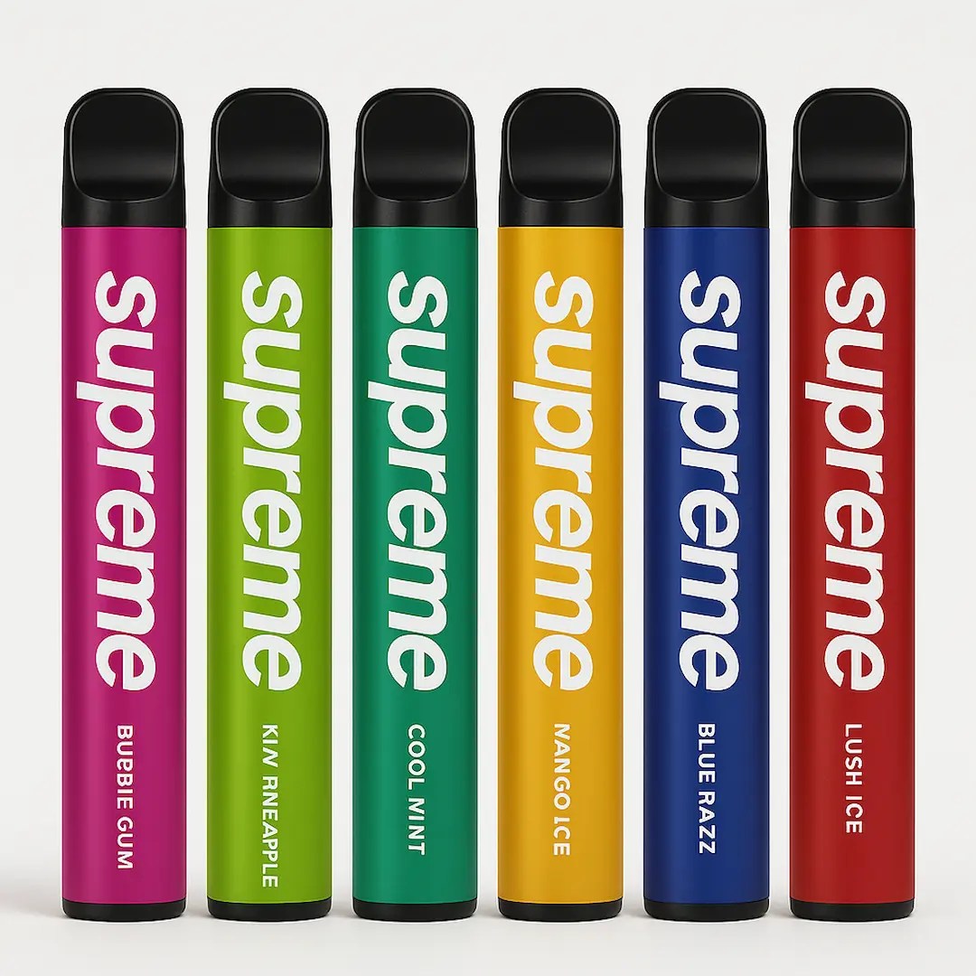 Six Supreme disposable vapes in assorted colors and flavors on a white studio background.