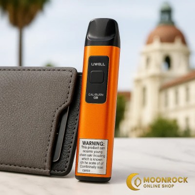 Orange Uwell Caliburn G3 standing by a gray wallet on marble with a blurred LA backdrop and Moonrock Online Shop logo.