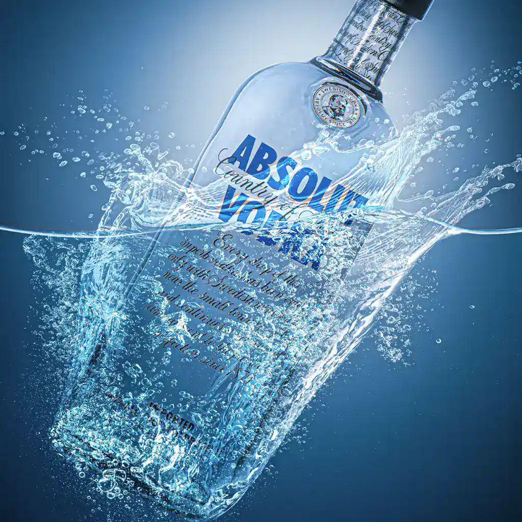 Absolut Vodka em garrafa em alta resolução com água cristalina e efeitos de splash, destacando a marca de vodka premium para conteúdos relacionados a bebidas alcoólicas e entretenimento.