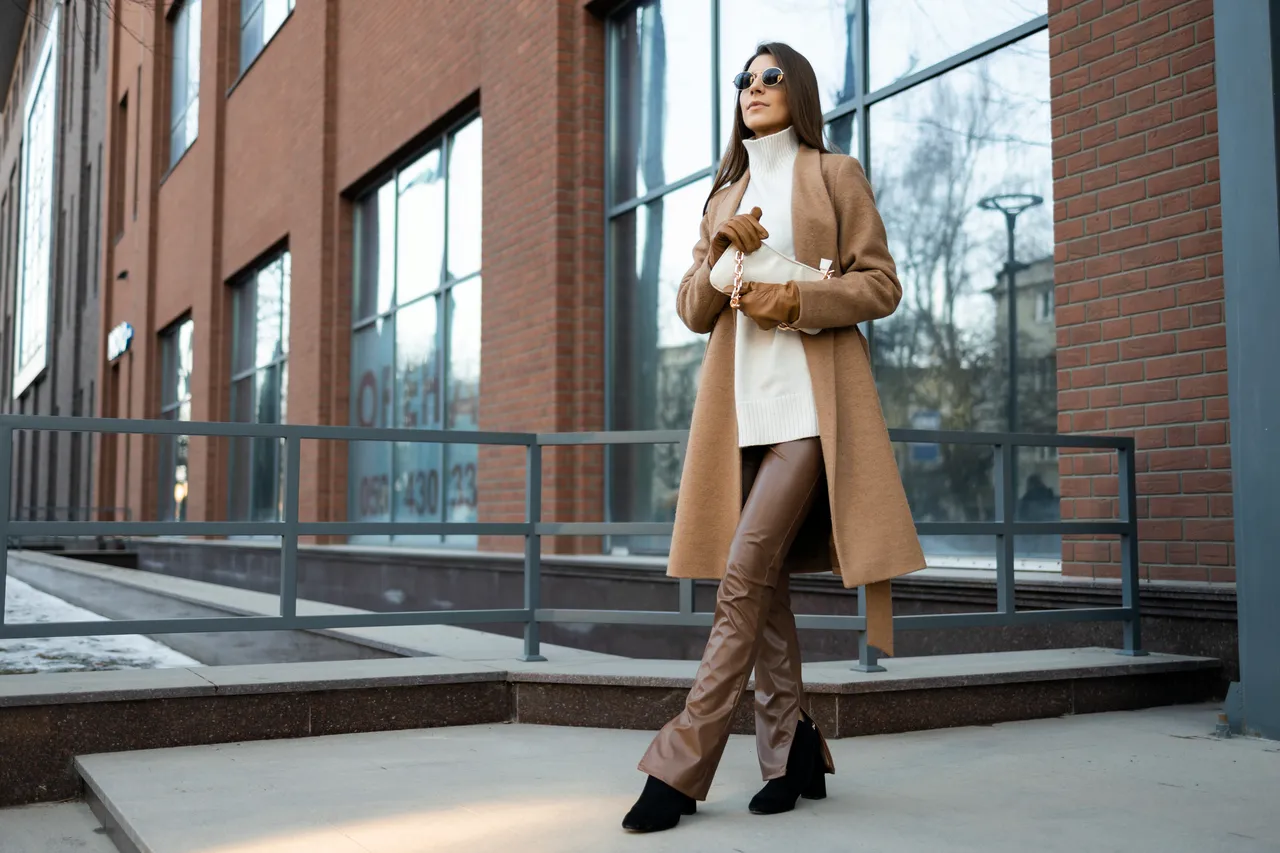 femme avec un manteau camel et un pull blanc