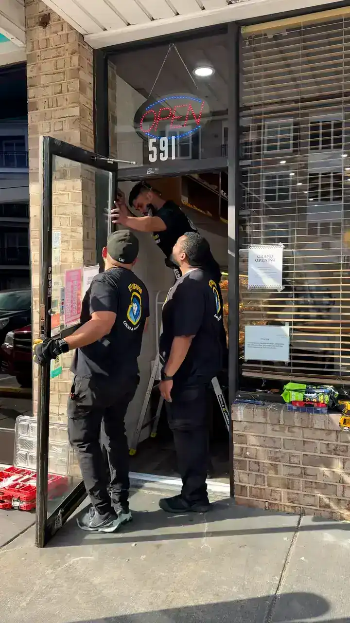 Team of three King Locksmith technician repairing a door in a commercial store in Rockville