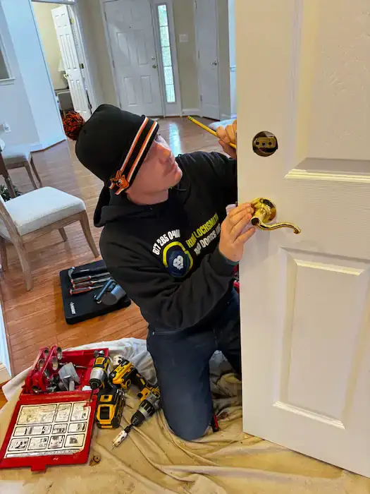 Residential locksmith rekeying a front door lock inside a Greenbelt, Maryland home with professional tools and careful workmanship.