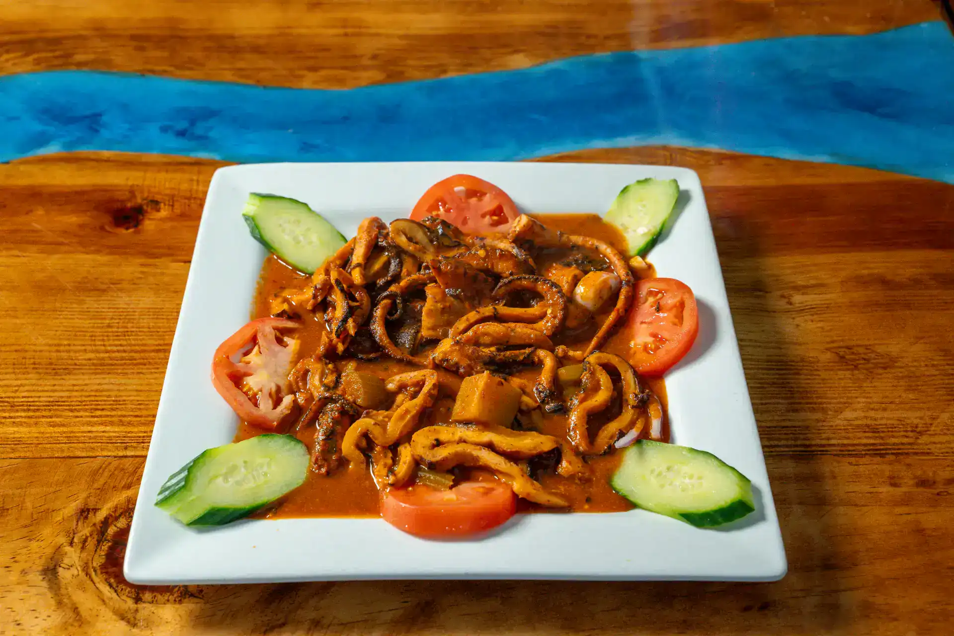 Pulpo Enojado seafood dish with vegetables on a white plate.