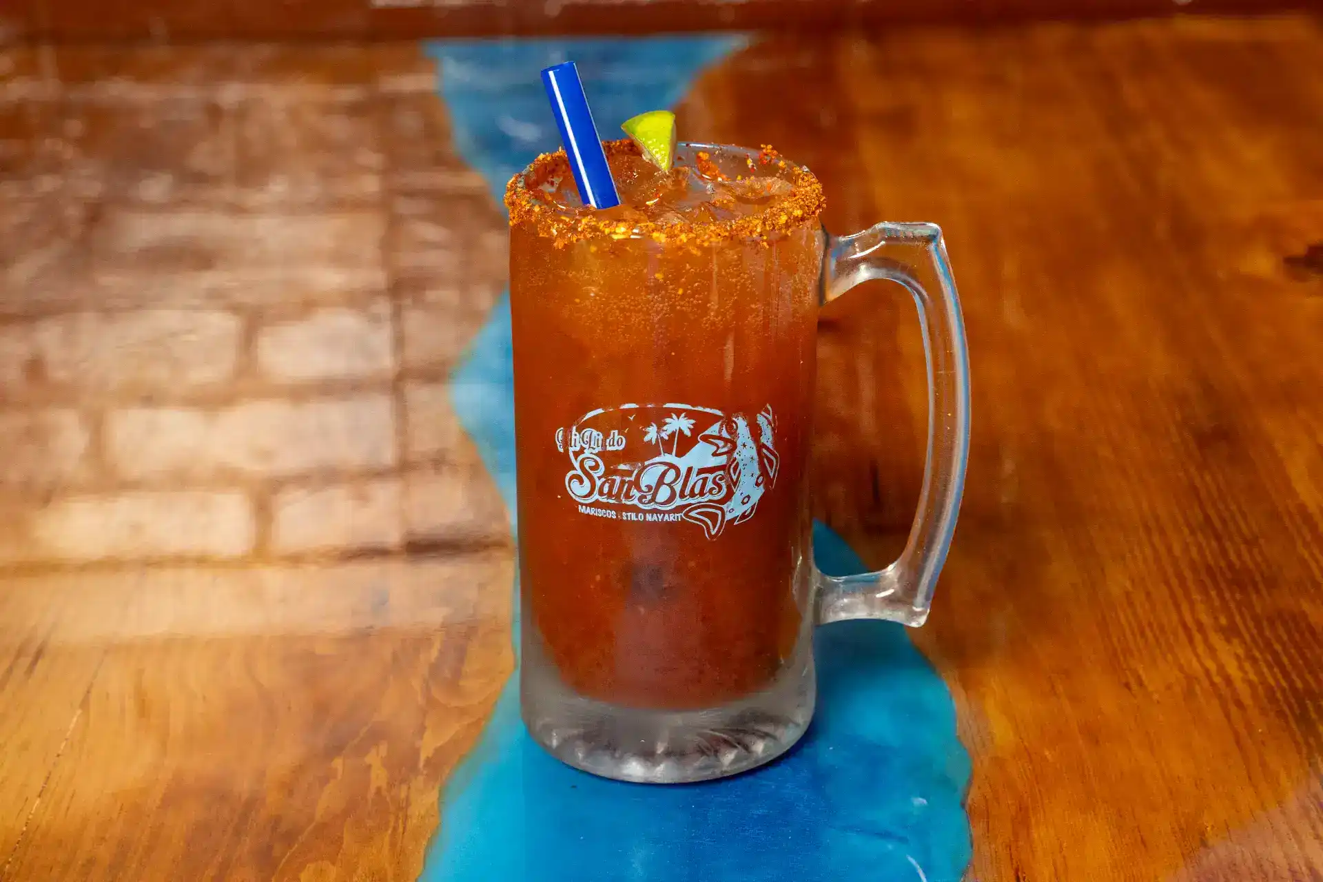Refreshing tropical cocktail with lime, straw, and crushed ice in a glass mug.