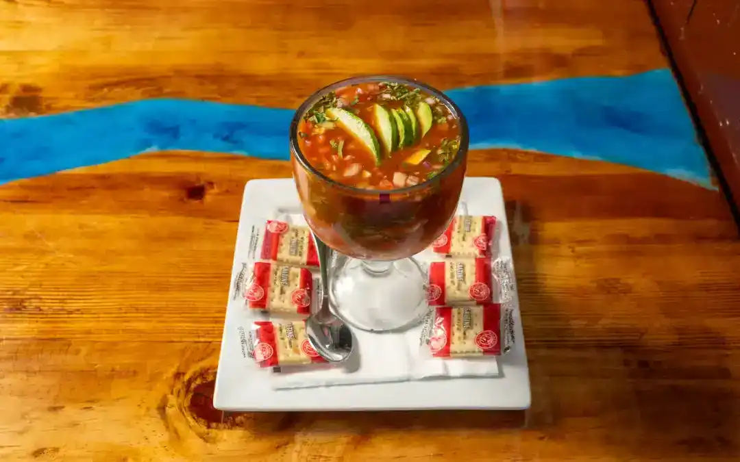 Seafood cocktail with shrimp, octopus, and vegetables in a glass.
