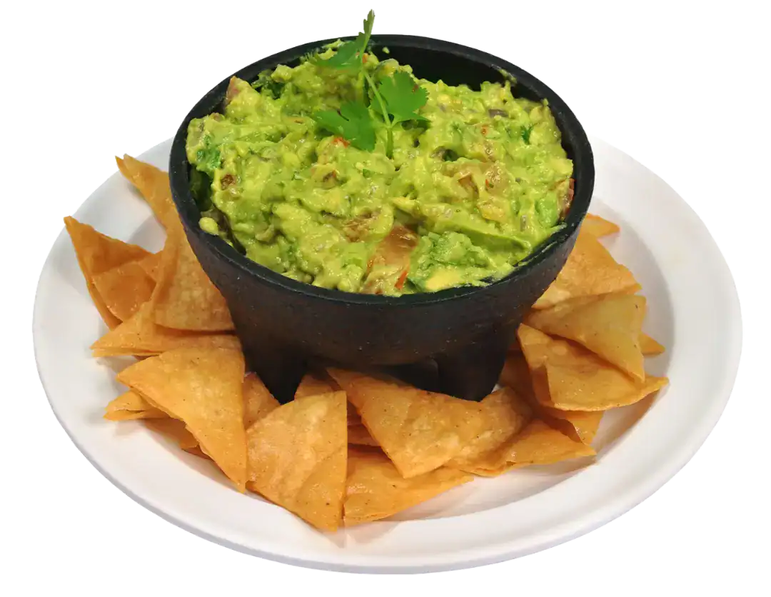 Creamy guacamole served with crispy tortilla chips on a white plate.