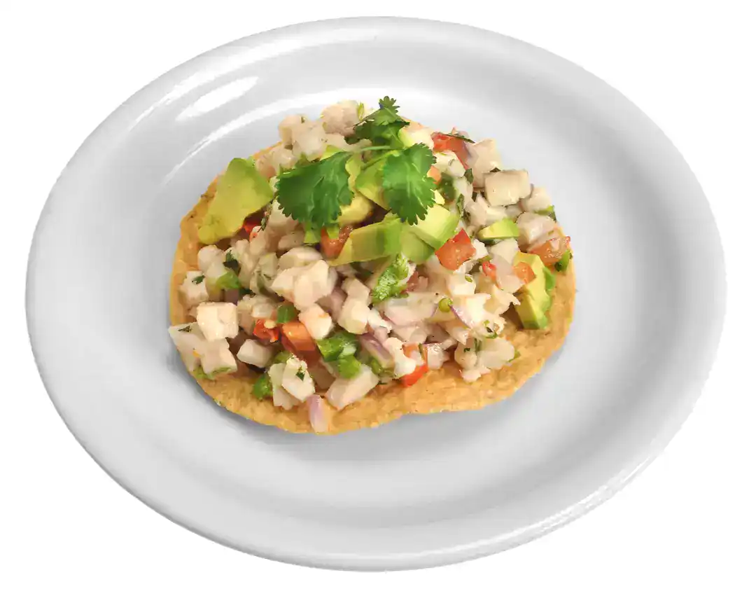 Ceviche de Pescado served on a tortilla chip with cilantro and vegetables.