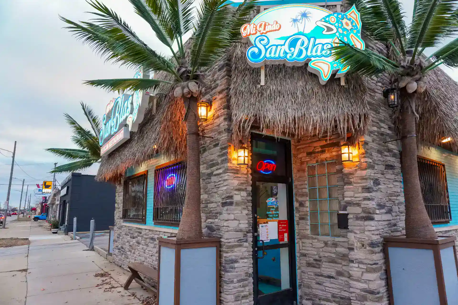 Exterior view of Mi Lindo San Blas restaurant with palm trees and tropical decor.
