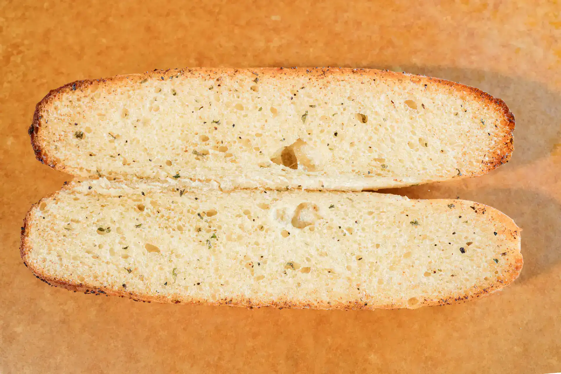Close-up of sliced garlic bread with a golden crust and soft interior.