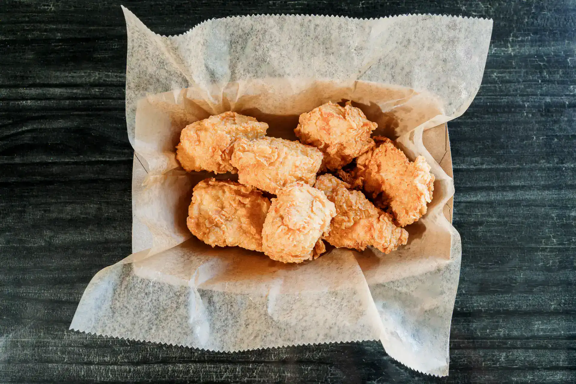Golden fried chicken tenders on parchment paper.