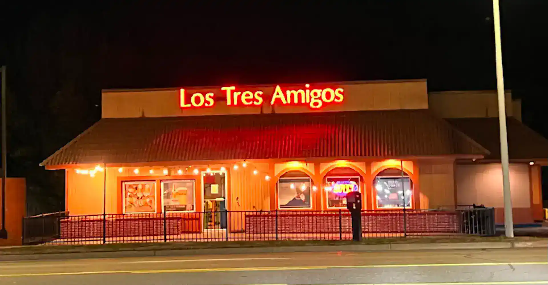Cozy Los Tres Amigos restaurant illuminated at night with inviting warm lighting.