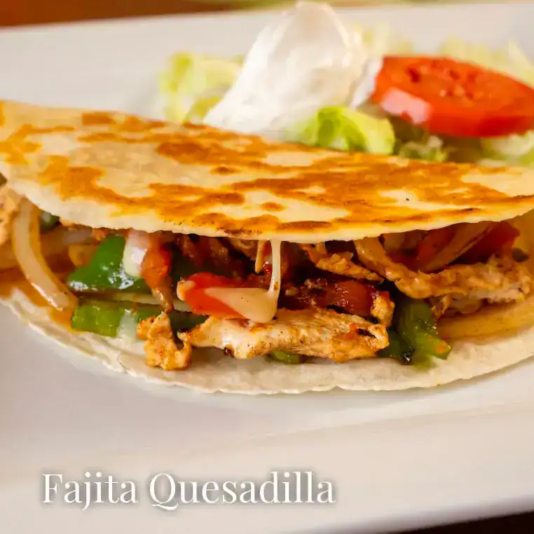 Tasty fajita quesadilla with grilled chicken, peppers, and cheese on a soft tortilla.