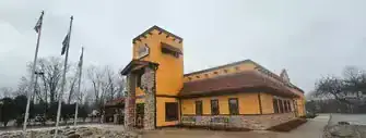 Bright yellow house with stone accents and a red-tiled roof.
