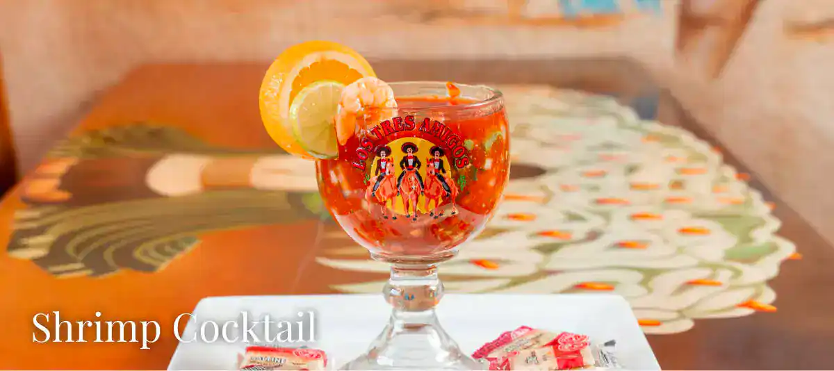 Shrimp cocktail served in a glass with lemon slice, perfect for menu selection.