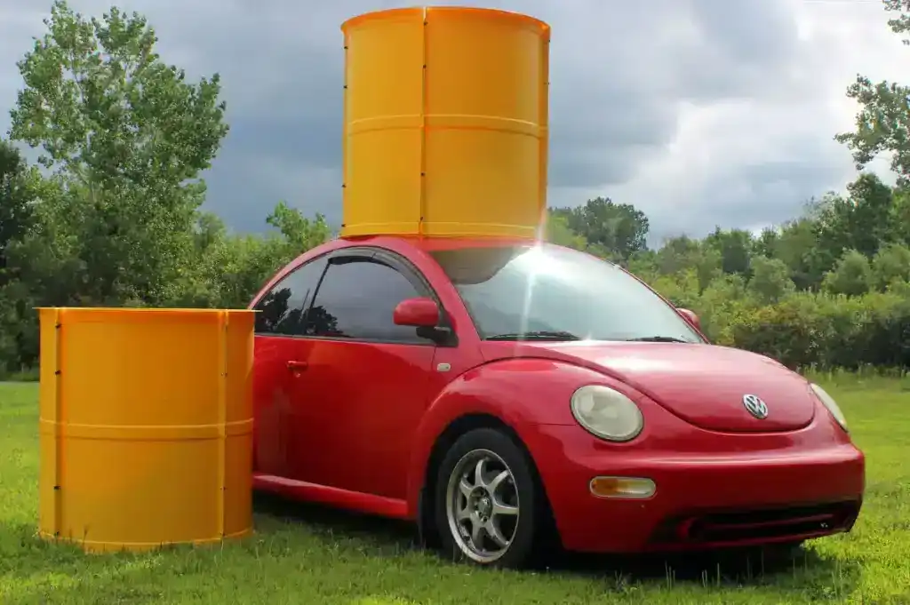 Vehicle with large yellow drum and barrier covers for safety and security.