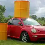 Vehicle with large yellow drum and barrier covers for safety and security.