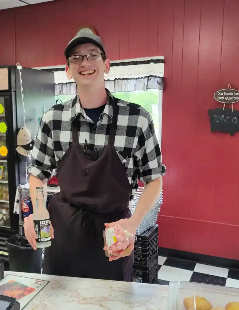 Mac's Meats employee standing behind the store counter.