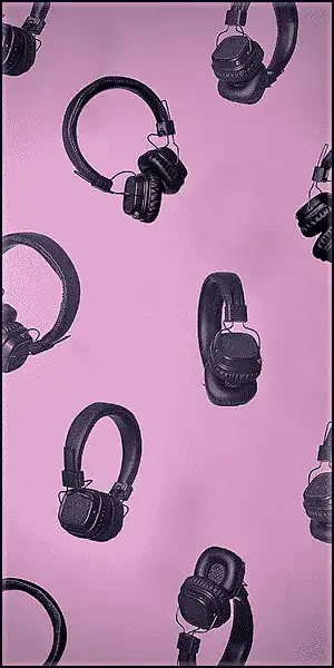 Several black over-ear headphones are evenly spaced against a solid pink background.