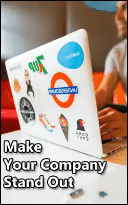Person typing on a laptop covered with various stickers, accompanied by the text "Make Your Company Stand Out.