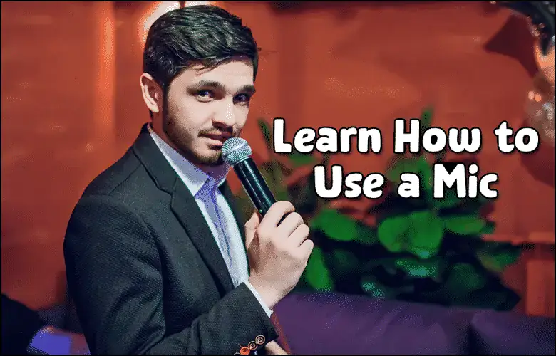 A man in a suit holds a microphone and looks at the camera. Text on the image reads, "Learn How to Use a Mic.