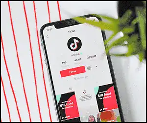 Smartphone displaying TikTok app with music and video content.
