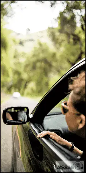 Person driving a car with sunglasses on, enjoying a scenic drive.