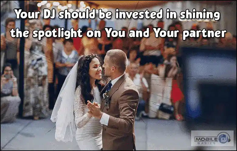 Wedding couple dancing with a crowd in the background, emphasizing spotlight on partners.