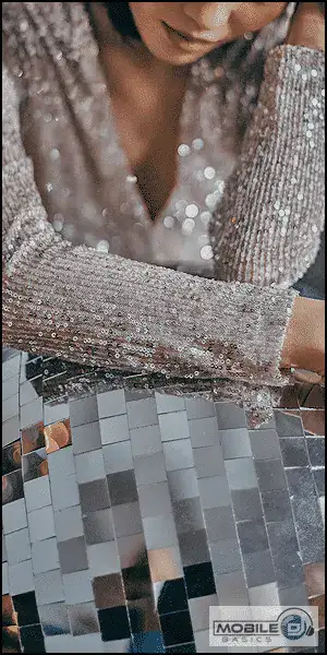 Close-up of a woman in a sparkling silver dress at a DJ setup.